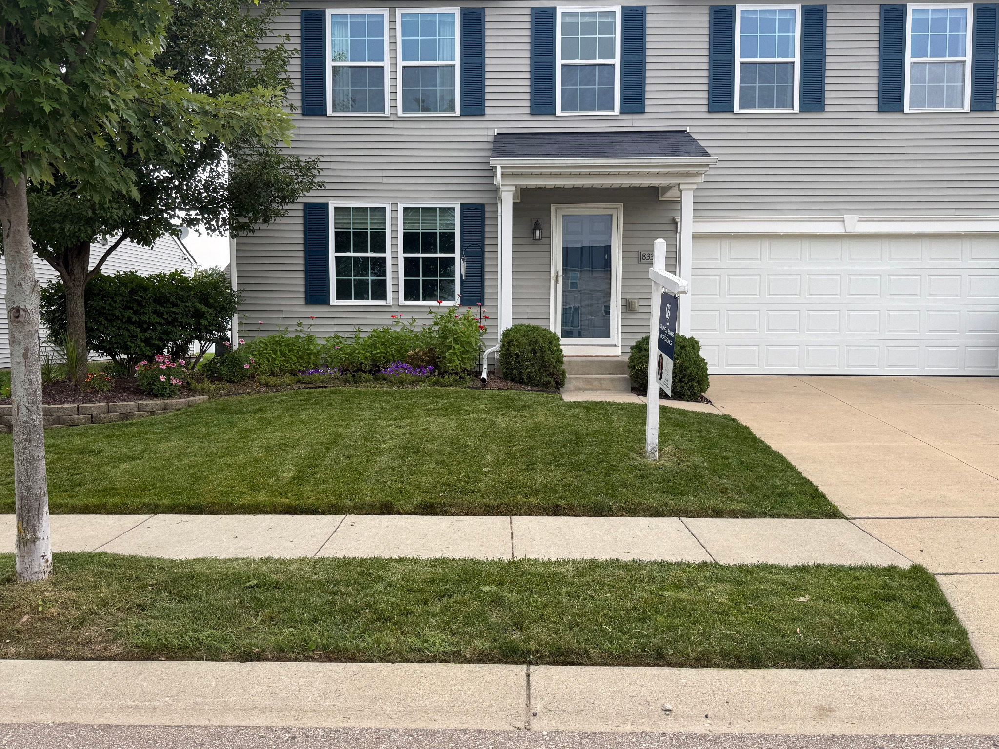 Freshly mowed front lawn with landscaped flower beds